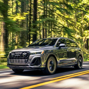 Side profile view of an Audi Q7 driving.